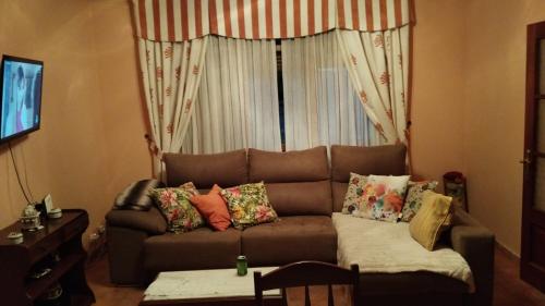 a living room with a brown couch and a window at Casa Herbellas in Cedeira