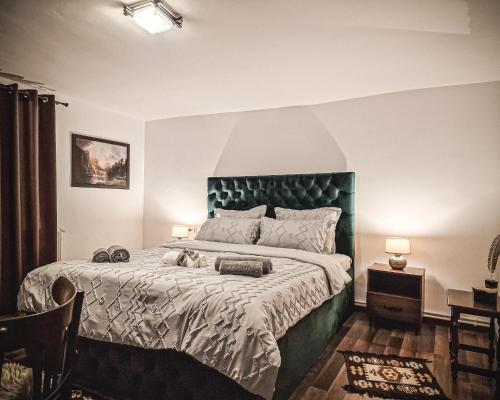 a bedroom with a large bed with a green headboard at Pensiunea Cocoș in Spulber