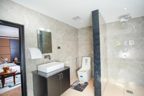 a bathroom with a sink and a toilet in it at Nagarjun Resort - Embrace Tranquility Natures Retreat Beyond the City in Kathmandu