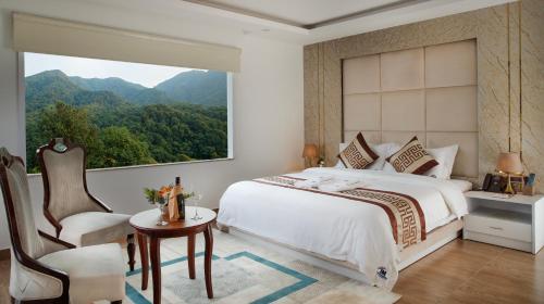 a bedroom with a bed and a large window at Nagarjun Resort - Embrace Tranquility Natures Retreat Beyond the City in Kathmandu
