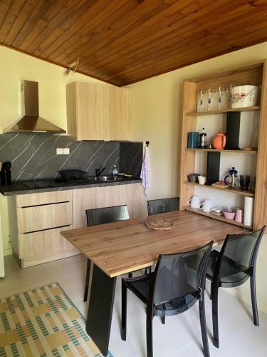 une cuisine avec une table et des chaises en bois dans l'établissement Appartement avec jardin, à Le Porge