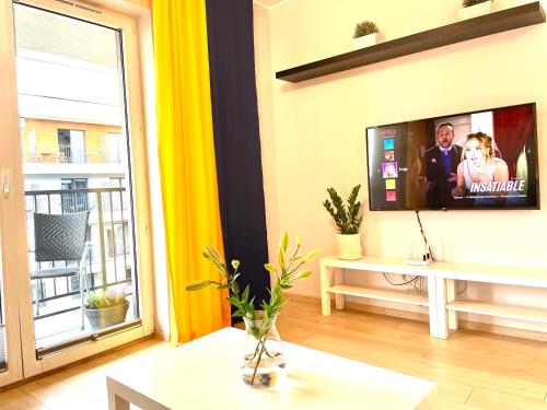 ザトルにあるFrojaの壁に薄型テレビが取り付けられたリビングルーム