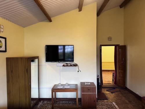 a living room with a tv on a wall at Trial Based Hotel in Coonoor