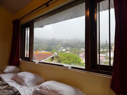 a bed in a room with a large window at Trial Based Hotel in Coonoor