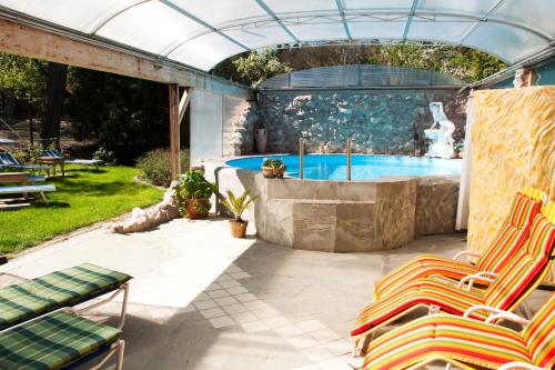 eine Terrasse mit Stühlen und einem Pool in der Unterkunft Familienhotel Hochrieß in Purgstall