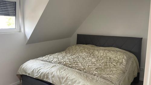 a bed in a white room with a window at Ferienwohnung Licina in Lauenburg