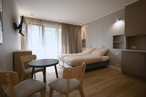 a bedroom with a bed and a table and chairs at Port Rewa in Rewa
