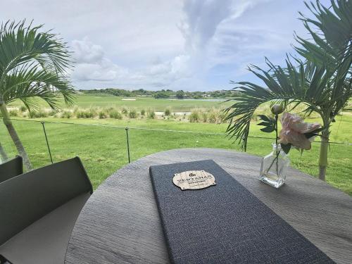 a table with a vase of flowers on top at Hard Rock Golf Cozy 1BR • Pool & Golf Views in Punta Cana