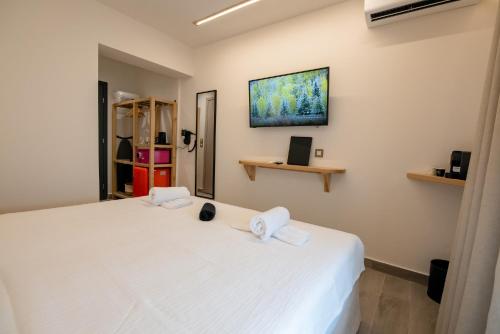 a bedroom with a white bed with towels on it at Ocean 11 Hotel in Skiathos Town