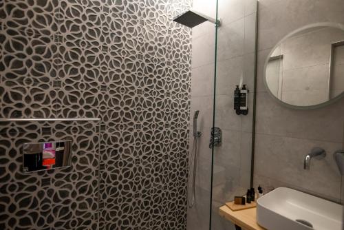 a bathroom with a shower with a sink and a mirror at Ocean 11 Hotel in Skiathos Town