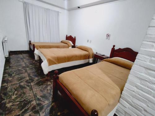 a room with four beds in a room at Hosteria Los Cuartos in Tafí del Valle