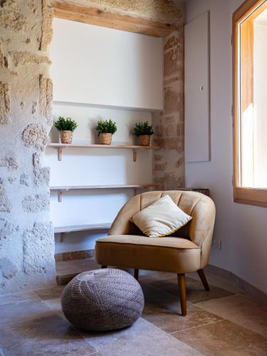 un salon avec une chaise et une fenêtre dans l'établissement Maison PALOMA, Maison de charme à deux pas du Pont du Gard, à Castillon-du-Gard