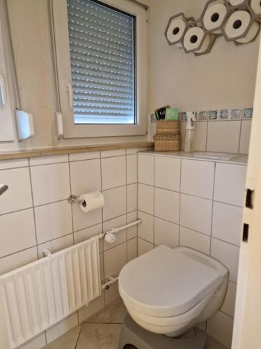 a bathroom with a white toilet and a window at Ferienwohnung an der Limburg in Weilheim an der Teck