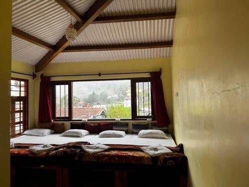 a bedroom with two beds and a large window at Trial Based Hotel in Coonoor
