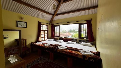 a bedroom with two beds in a room with a window at Trial Based Hotel in Coonoor