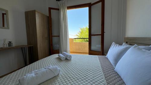 a bedroom with a bed with two stuffed animals on it at Villa Kardi in Vlikhádha