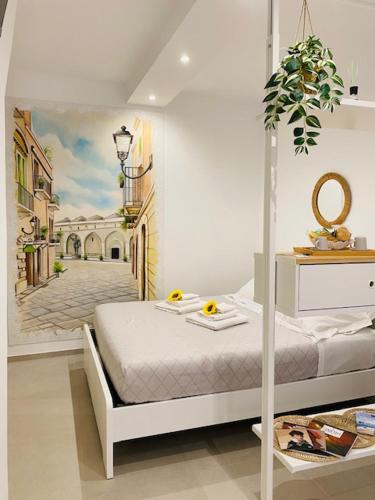 a bedroom with a bed and a painting of a street at Bell'Arè in Barletta
