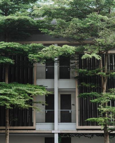 a building with trees in front of it at Anugrah Hotel Sukabumi in Sukabumi