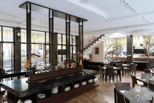 a restaurant with tables and chairs and a staircase at Anugrah Hotel Sukabumi in Sukabumi