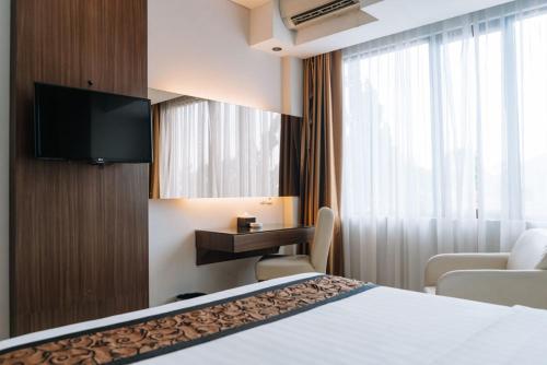 a hotel room with a bed and a television at Anugrah Hotel Sukabumi in Sukabumi