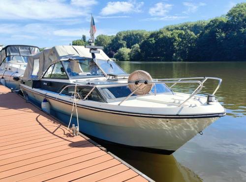 un barco está atracado en un muelle sobre el agua en Wake Port Boat, ubytování na lodi, en Brandýs nad Labem-Stará Boleslav