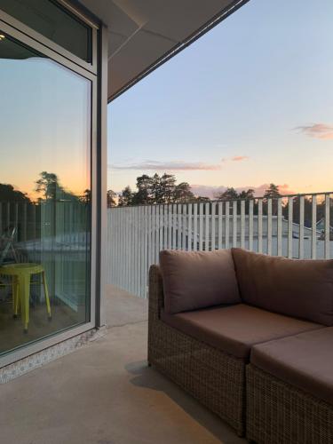 a living room with a couch on a balcony at Lägenhet på stranden i Åhus med havsutsikt och närhet till Spa & utomhuspool in Åhus