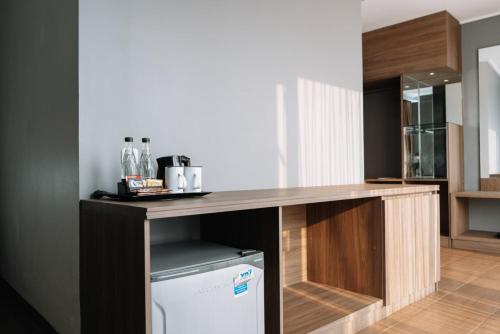 a kitchen with a wooden counter with a dishwasher at Anugrah Hotel Sukabumi in Sukabumi