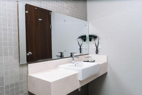 a bathroom with two white sinks and a mirror at Anugrah Hotel Sukabumi in Sukabumi
