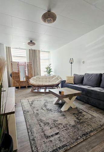 a living room with a blue couch and a table at Zeeuwshuisje in Vlissingen