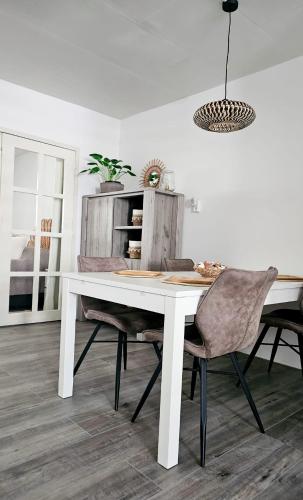 a dining room with a white table and chairs at Zeeuwshuisje in Vlissingen