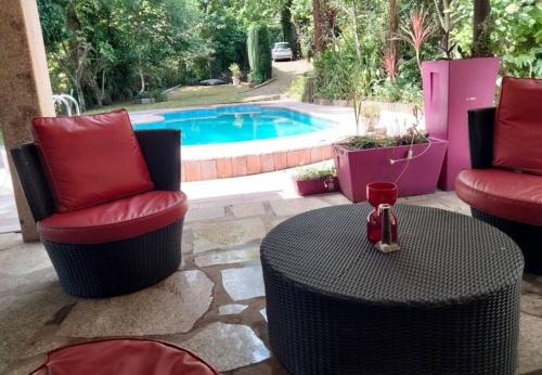 a patio with two chairs and a table and a pool at Pool House au cœur du Gérès à Rio Caldo in Rio Caldo