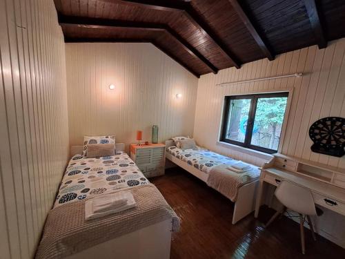 a room with two beds and a desk and a window at Pool House au cœur du Gérès à Rio Caldo in Rio Caldo