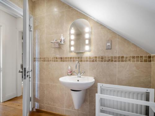 a bathroom with a sink and a mirror on the wall at Ard Apartment, Roundstone in Roundstone