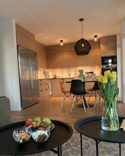 a kitchen and dining room with a vase of flowers on a table at Lägenhet på stranden i Åhus med havsutsikt och närhet till Spa & utomhuspool in Åhus