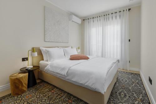 a bedroom with a large white bed and a window at Dimitris Residence in Tivat