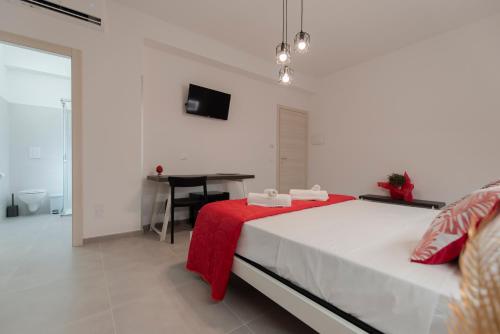 a bedroom with a bed with a red blanket and a desk at Bed and Breakfast Da Francesca in Castelluzzo