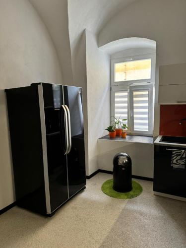 una cucina con frigorifero nero e finestra di Apartman I Ubytovani v centru Jihlavy a Jihlava