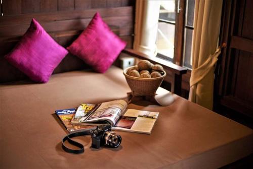 a table with a book and a magazine and a bowl of nuts at Lilu Pai in Pai