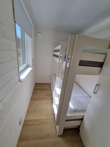 a small room with two bunk beds and a window at Fridfullt läge, stuga med sjöutsikt in Säffle