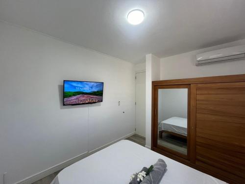 a bedroom with a bed and a tv on the wall at Seascape Modern Accomodation Near CLUB MED ALBION in Albion