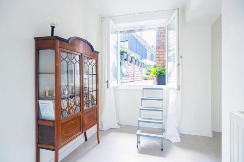 une pièce avec une armoire en bois et une fenêtre dans l'établissement Le Carré d Or Appartement Terrasse vue Cathédrale, à Strasbourg
