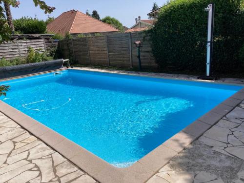 a swimming pool with blue water in a yard at Élégance Paloise in Pau