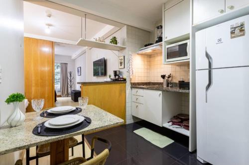 a kitchen with a table and a refrigerator at Maximus Luxury in Perdizes - Flat at the hotel in Sao Paulo