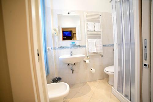 a bathroom with a sink and a toilet and a mirror at Hotel Demo' in Milan