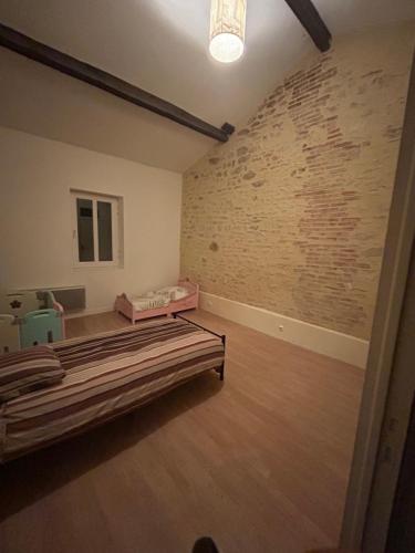 une chambre avec un lit et un mur de briques dans l'établissement Bornel, à Saint-Martin-des-Fontaines