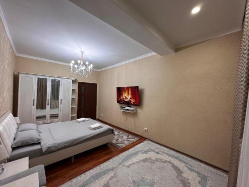 a bedroom with a bed and a fire painting on the wall at Cozy apartment in the city center in Bishkek