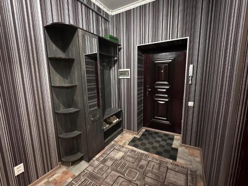 a hallway with wood paneled walls and a door at Cozy apartment in the city center in Bishkek