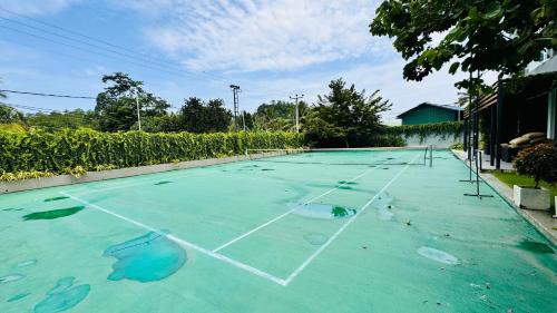 a tennis court is covered in green paint at MACA Canterbury Apartment in Gonapola