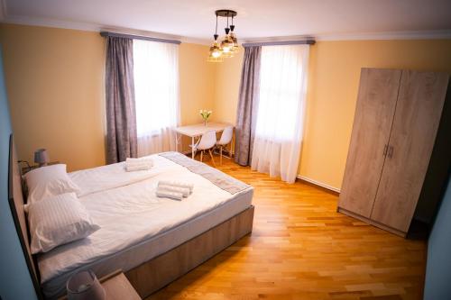 a bedroom with a bed and a table and windows at Lily's Guest House in Shahumyan