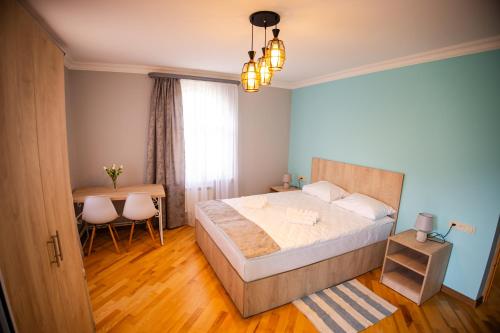 a bedroom with a large bed and a table at Lily's Guest House in Shahumyan